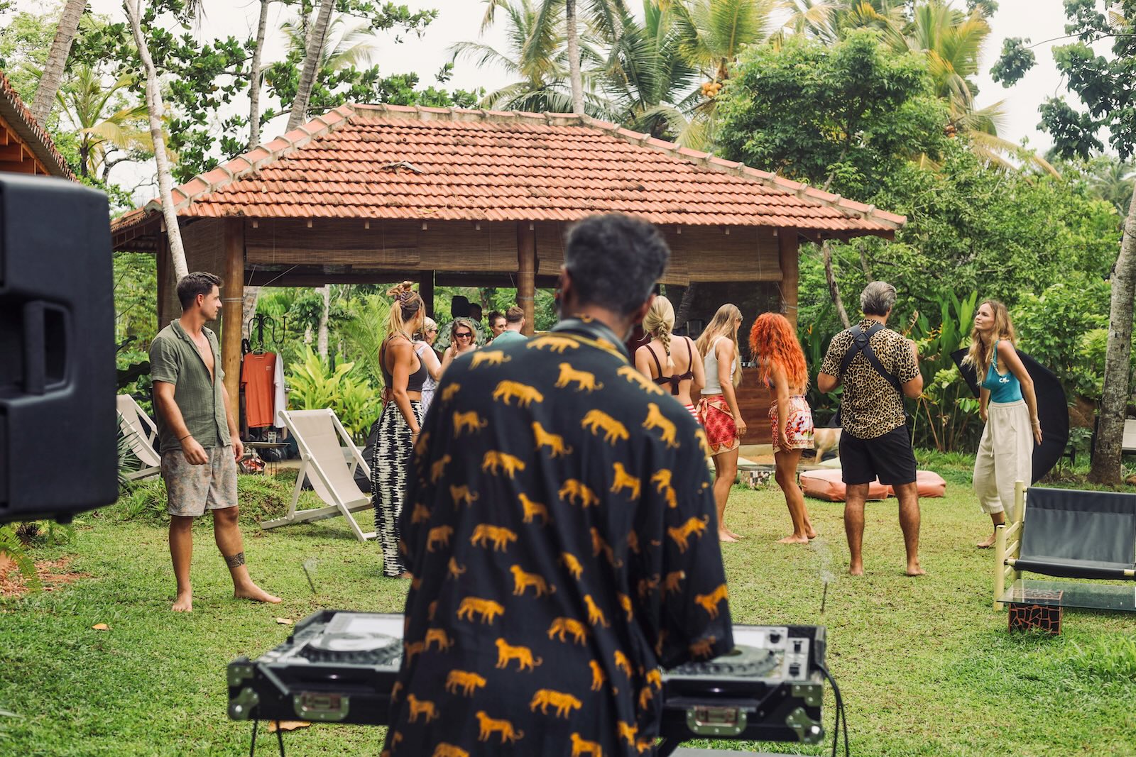A private event in the garden — DJ at the decks, people dancing barefoot on the grass